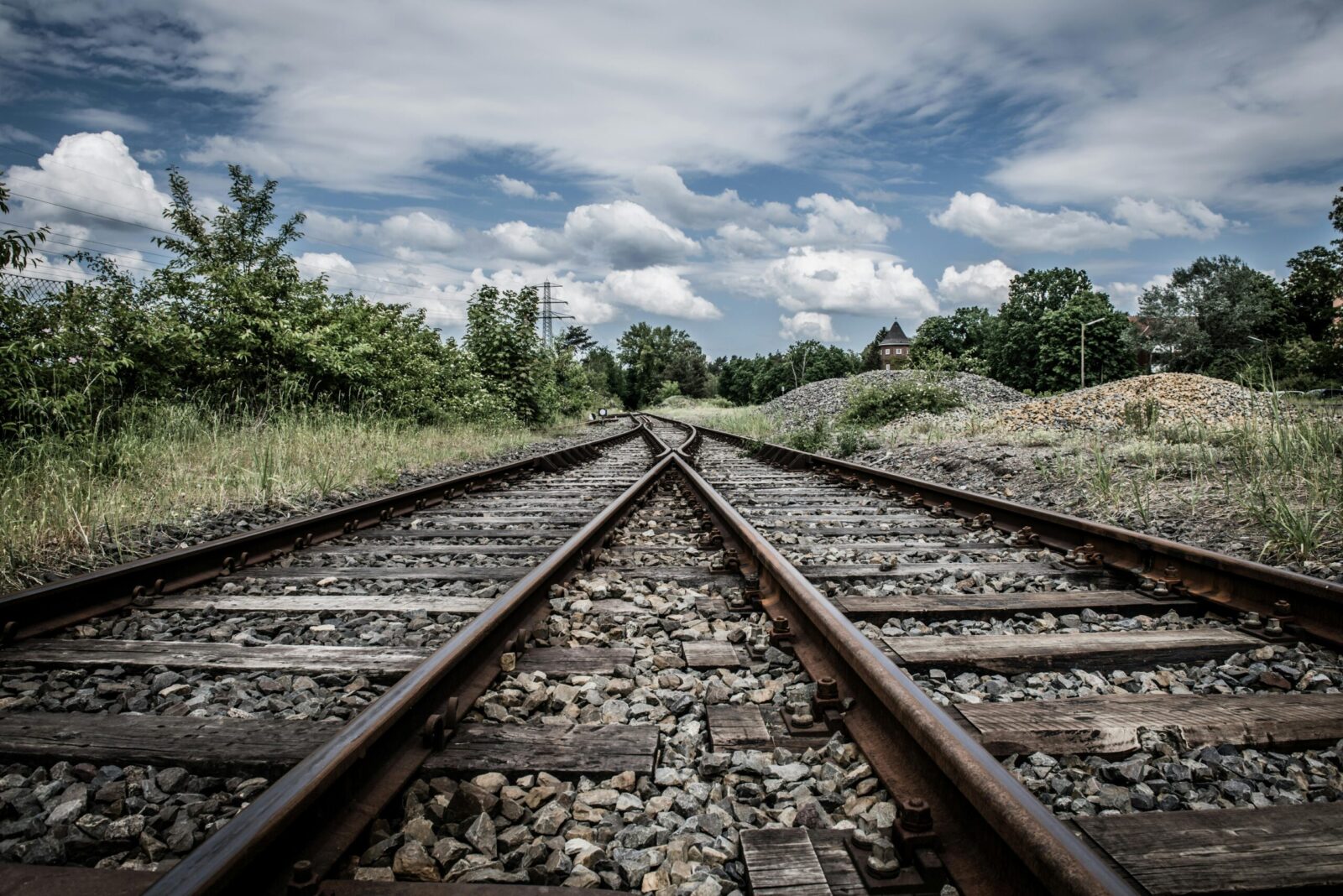 Rustic railway tracks under a cloudy sky in rural Geesthacht, perfect for travel and transport themes.