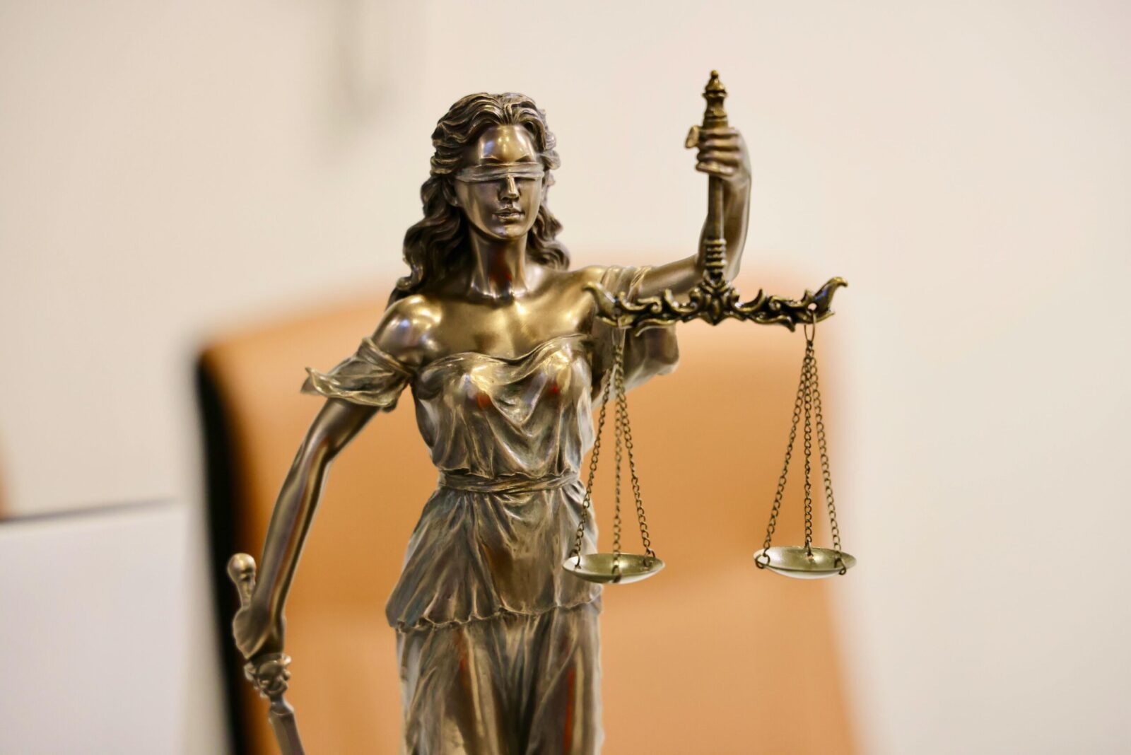 Close-up of Lady Justice statue holding scales, symbolizing justice and fairness.