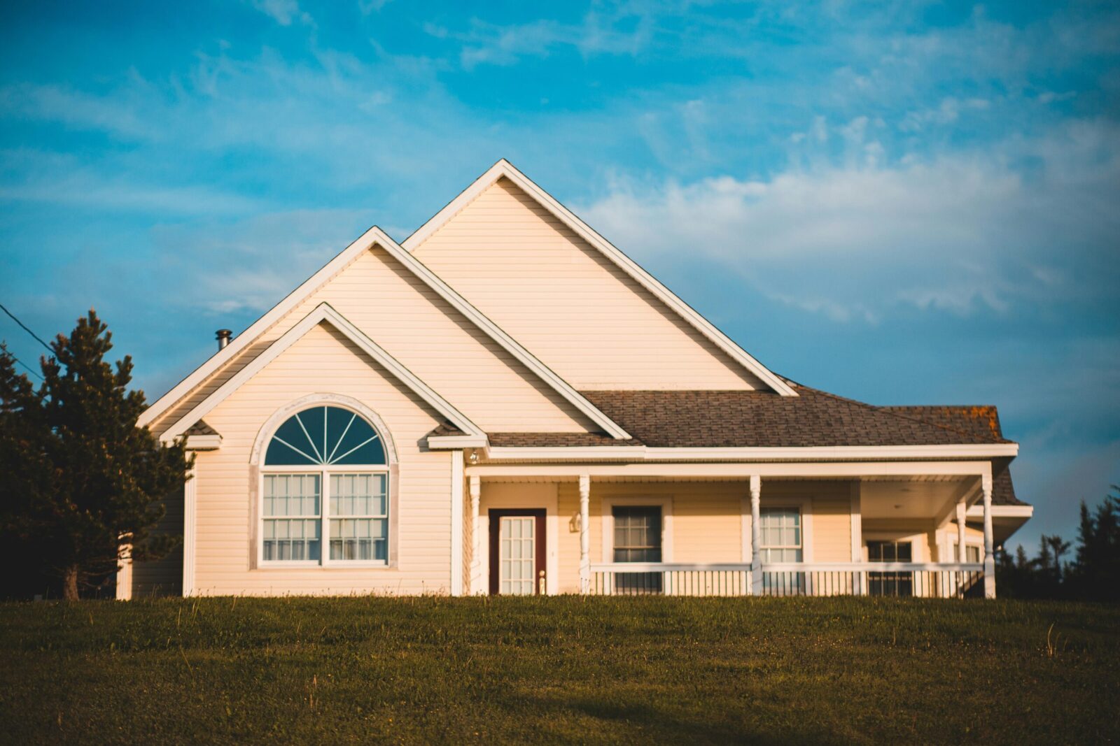Exterior of modern house with triangle shaped roof and round window located in garden