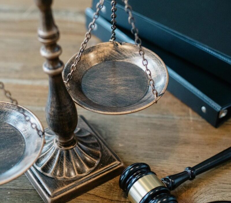 From above of judicial symbols consisting of Scales of Justice and small judge hammer with curly handle