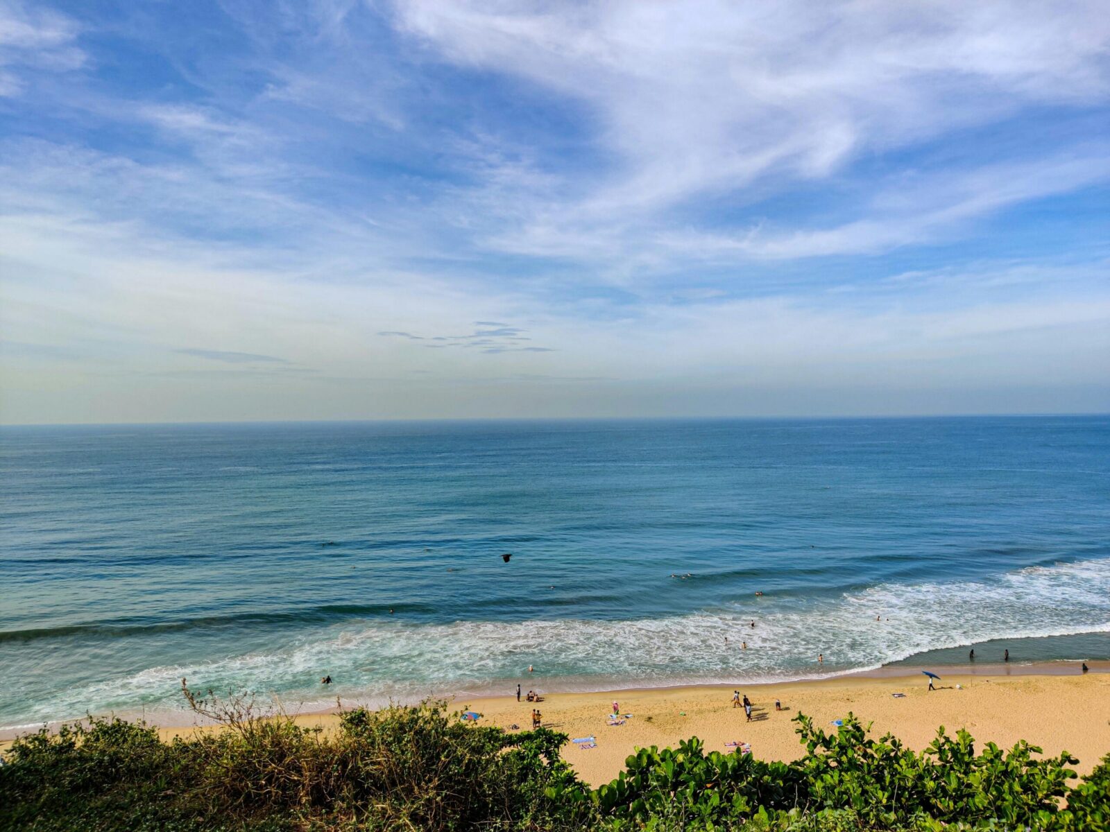Beautiful sandy beach and turquoise waters in Varkala, Kerala, India, under a clear blue sky.