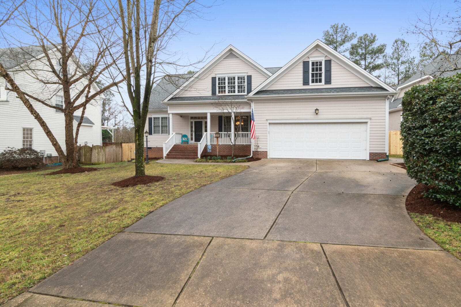 A well-maintained suburban house exterior with a large driveway, perfect for real estate listings.