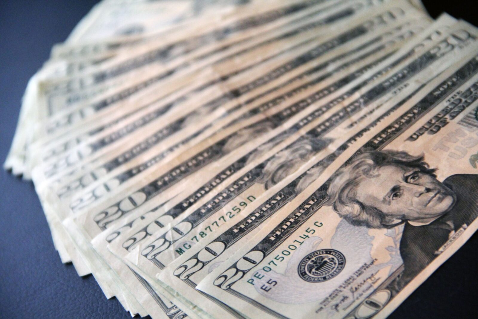 Close-up shot of multiple US twenty dollar bills spread out, symbolizing wealth and finance.
