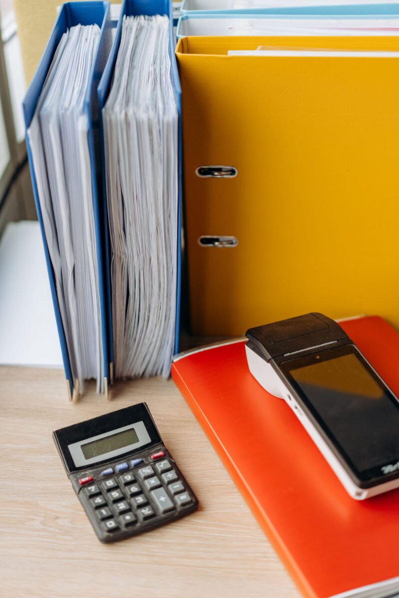Organized office desk with a calculator, files, and documents for efficient work.